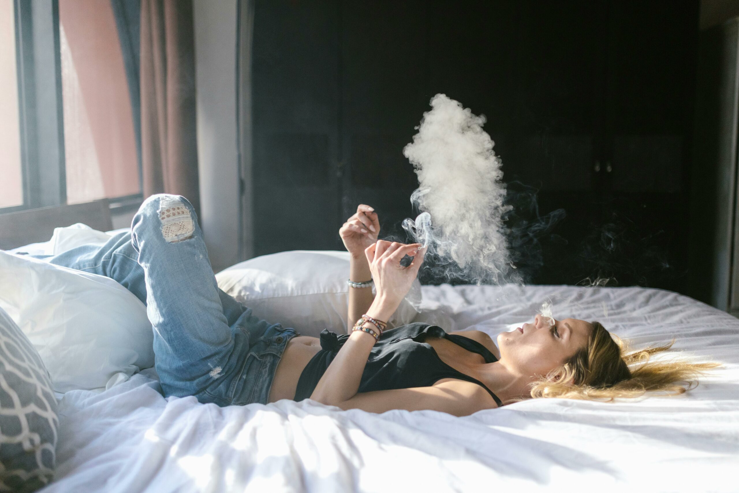 woman smoking on the bed